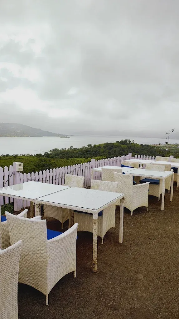 Neatly set white tables on the lakeside terrace in Pawna